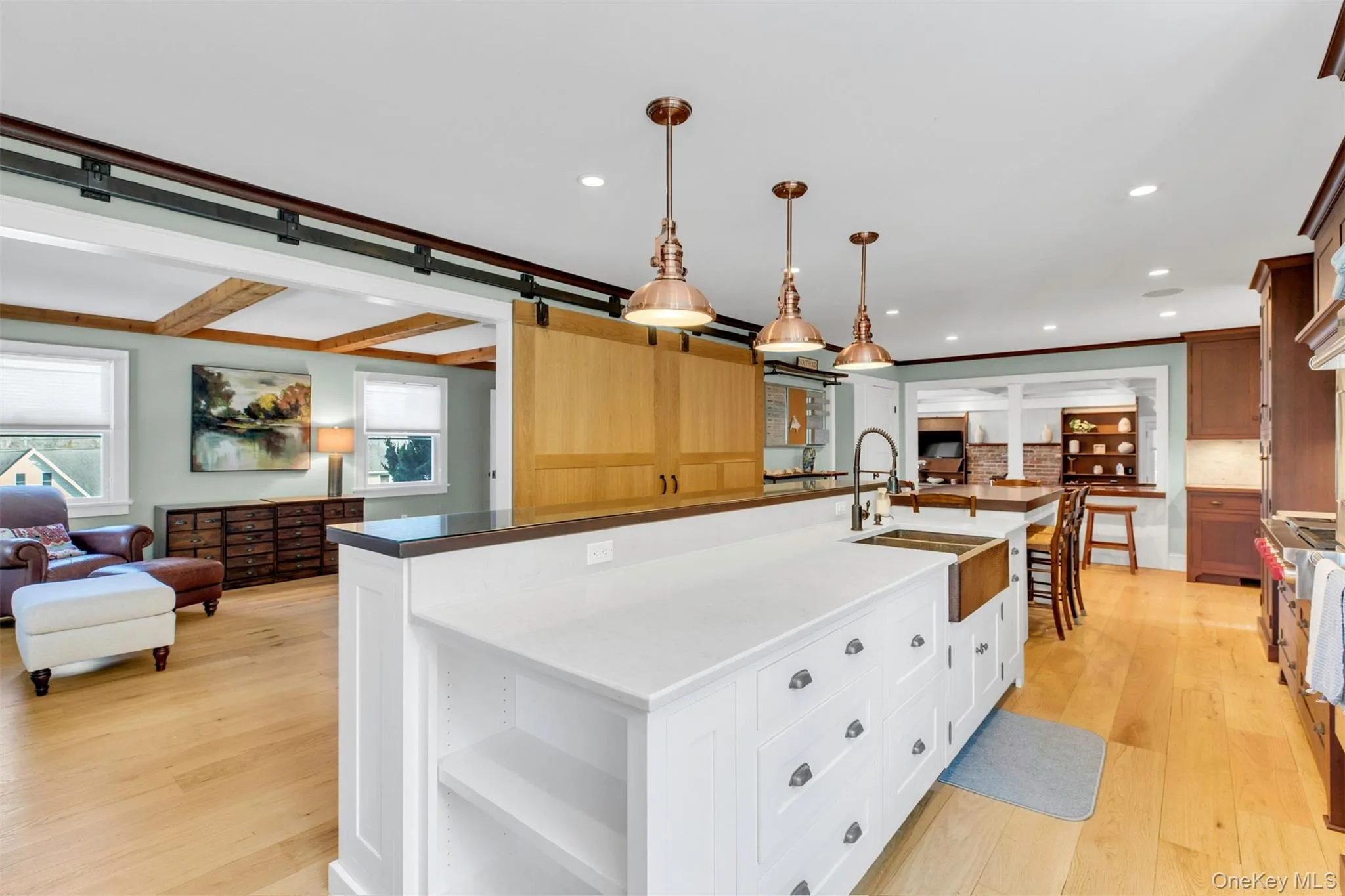 Kitchen featuring open floor plan, light wood-style floors, open shelves, pendant lighting, and beam ceiling Kitchen featuring open floor plan, light wood-style floors, open shelves, pendant lighting, and beam ceiling