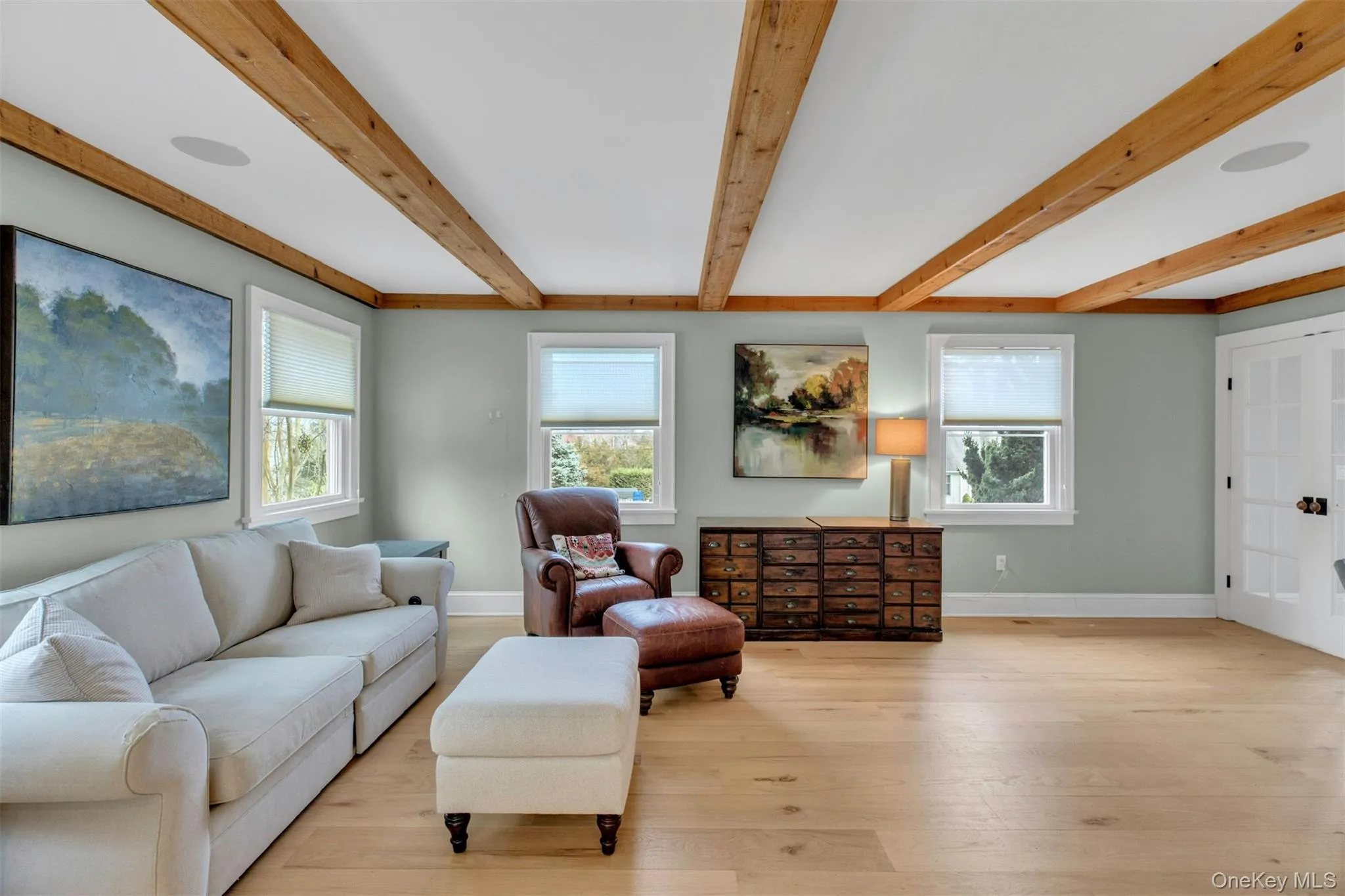 Living area with light wood finished floors and beam ceiling Living area with light wood finished floors and beam ceiling