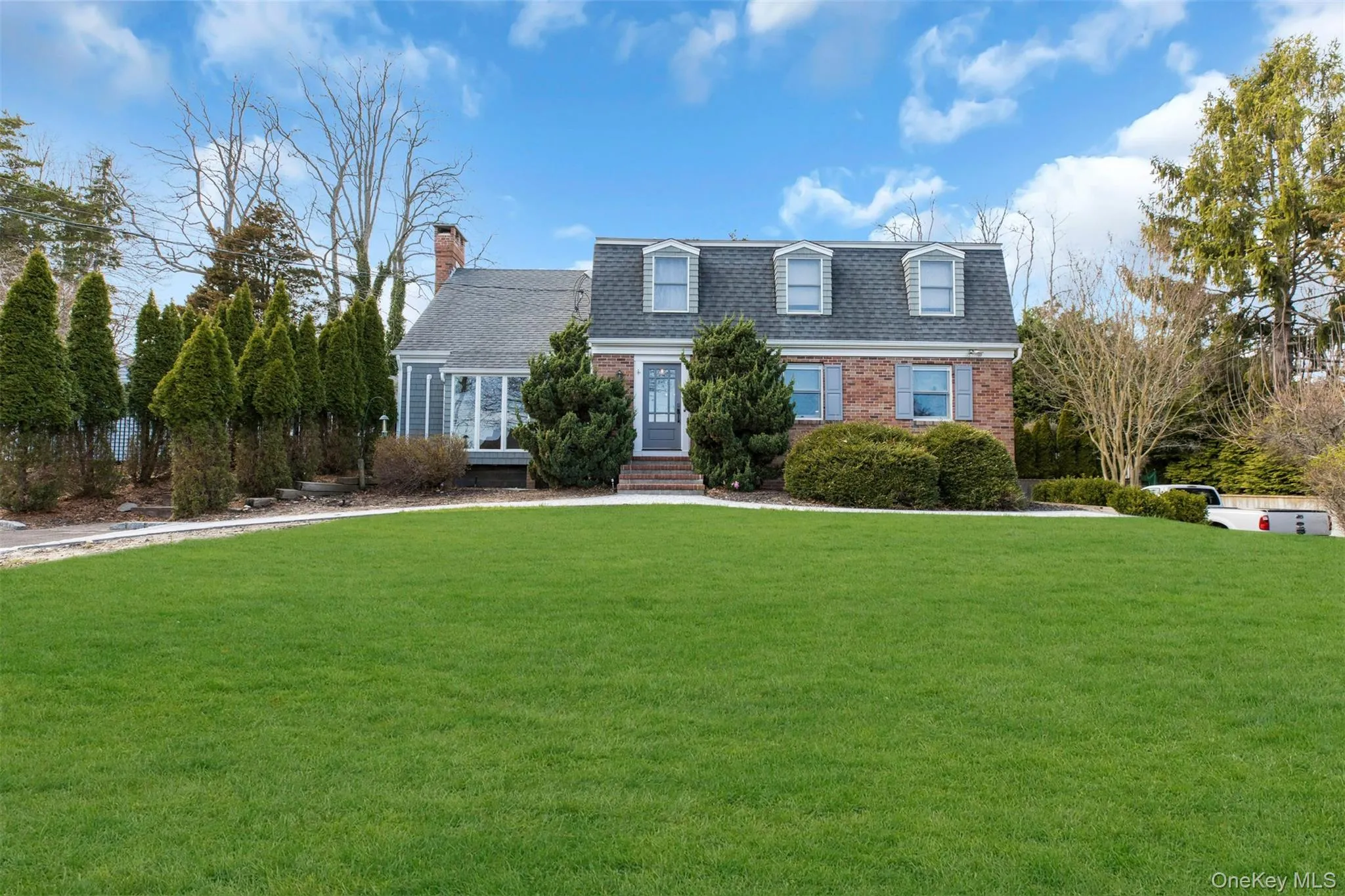 View of front of property featuring brick siding, a front lawn, a shingled roof, a chimney, and entry steps View of front of property featuring brick siding, a front lawn, a shingled roof, a chimney, and entry steps