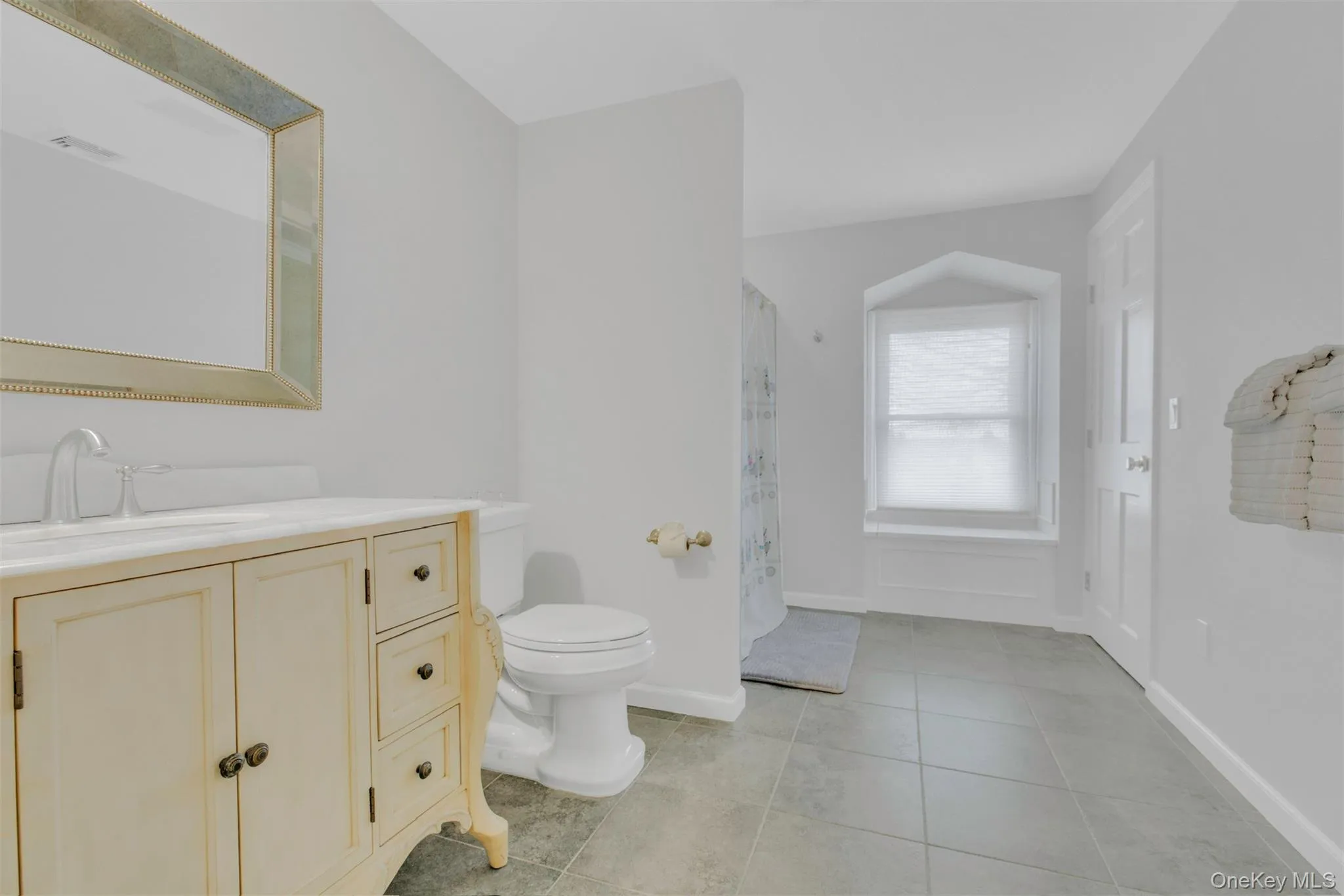 Full bathroom with light tile patterned flooring, vanity, and a shower with curtain Full bathroom with light tile patterned flooring, vanity, and a shower with curtain