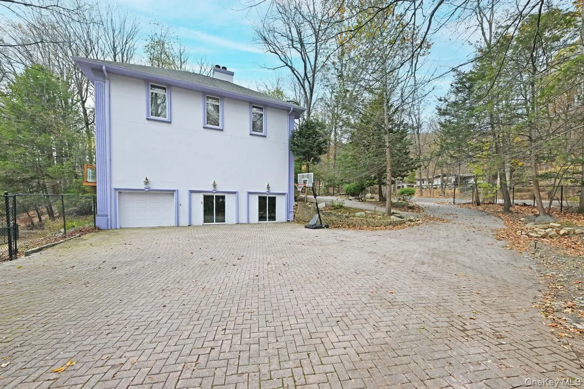 View of home's exterior featuring stucco siding, a chimney, decorative driveway, an attached garage, and a patio area View of home's exterior featuring stucco siding, a chimney, decorative driveway, an attached garage, and a patio area