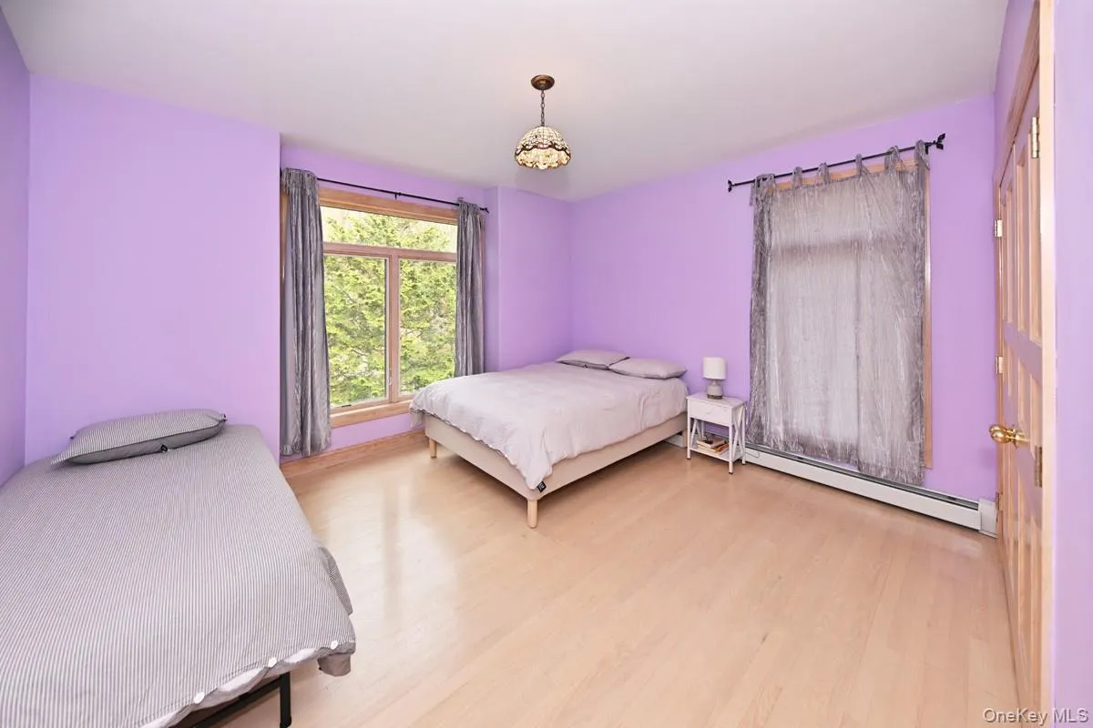 Bedroom featuring a baseboard radiator and light wood-type flooring Bedroom featuring a baseboard radiator and light wood-type flooring
