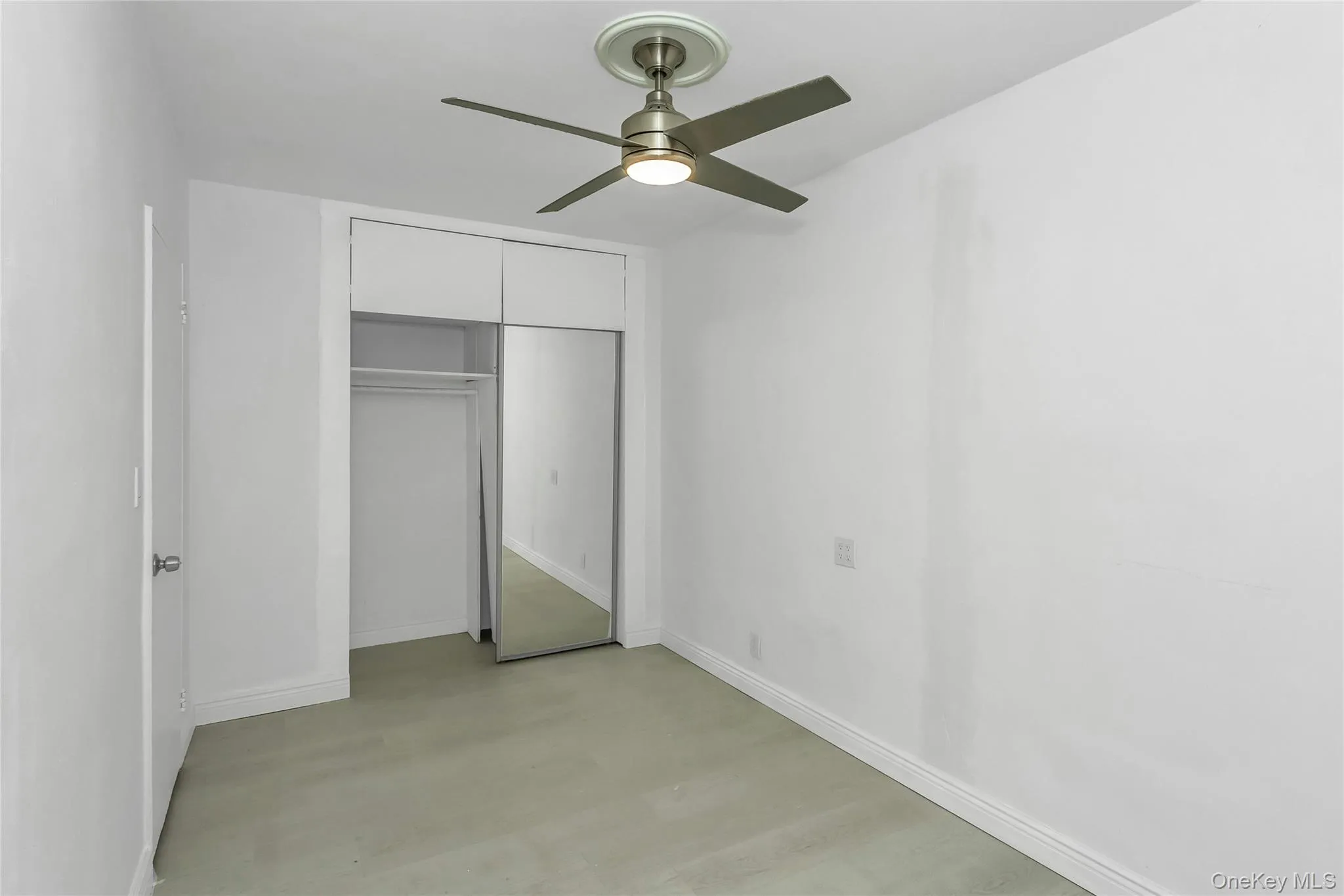 Unfurnished bedroom featuring ceiling fan, a closet, and wood finished floors Unfurnished bedroom featuring ceiling fan, a closet, and wood finished floors