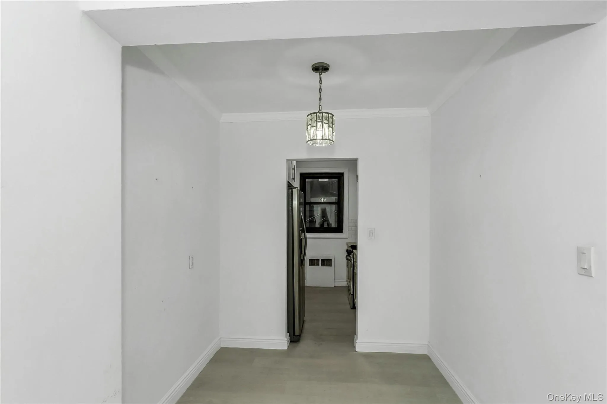 Hallway featuring ornamental molding and a chandelier Hallway featuring ornamental molding and a chandelier