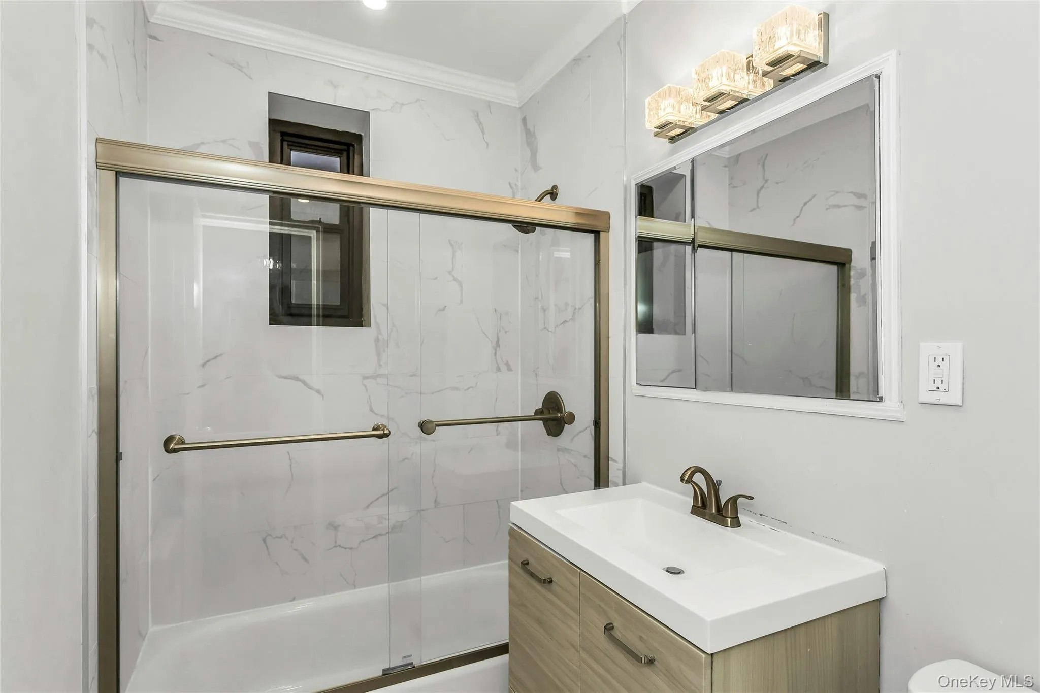 Bathroom with combined bath / shower with glass door, crown molding, and vanity Bathroom with combined bath / shower with glass door, crown molding, and vanity