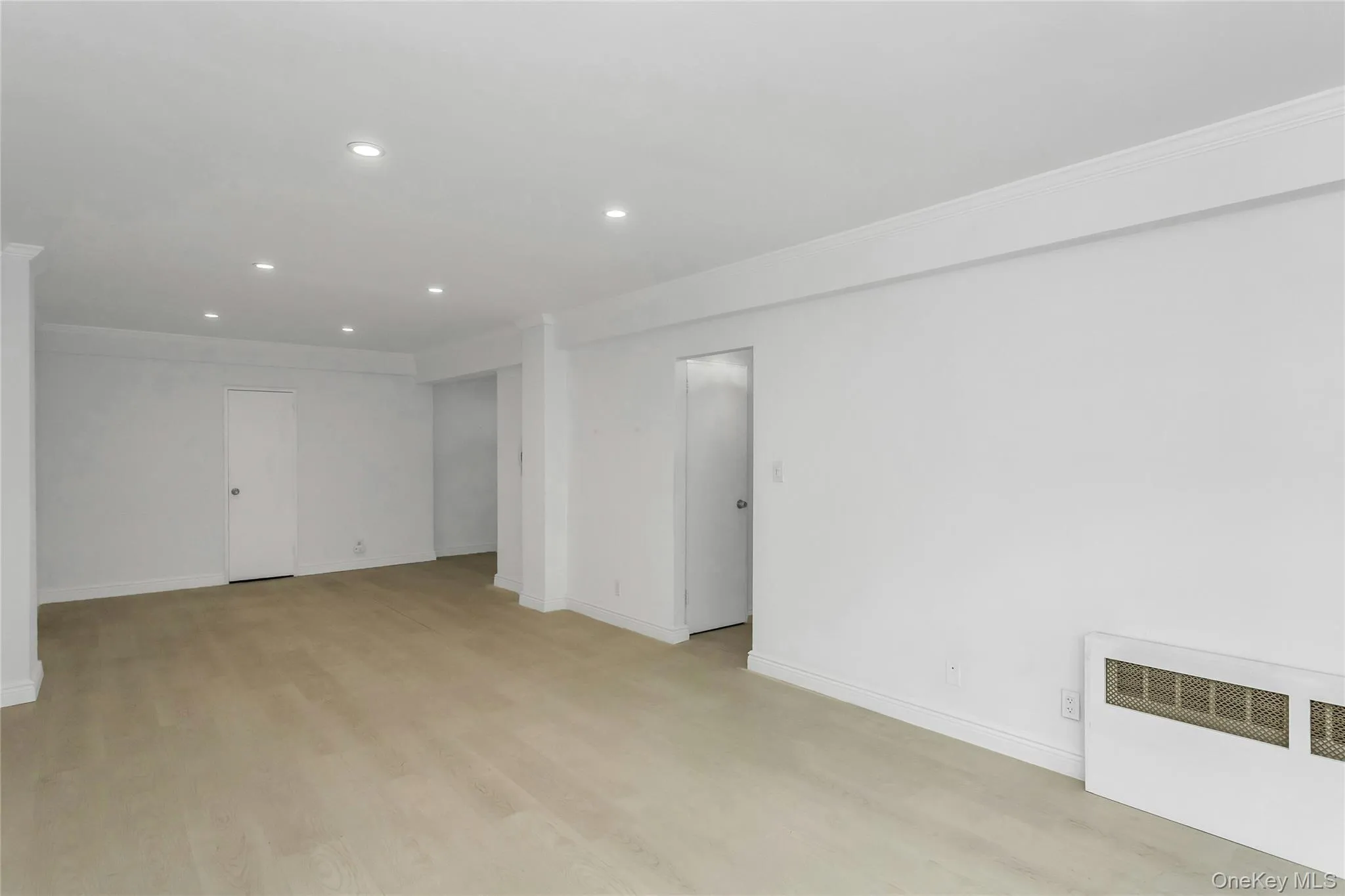 Spare room with radiator heating unit, light wood finished floors, recessed lighting, and ornamental molding Spare room with radiator heating unit, light wood finished floors, recessed lighting, and ornamental molding