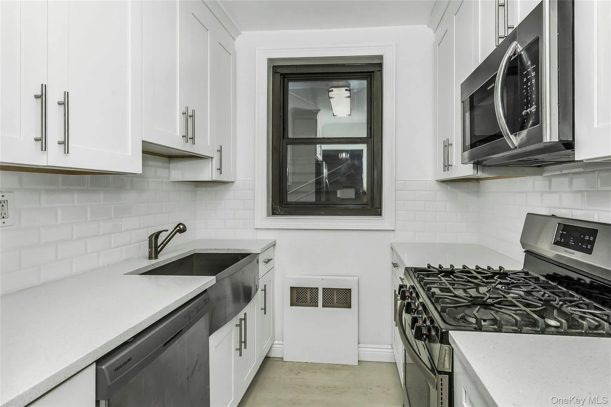 Kitchen with stainless steel appliances, white cabinetry, and light stone counters Kitchen with stainless steel appliances, white cabinetry, and light stone counters