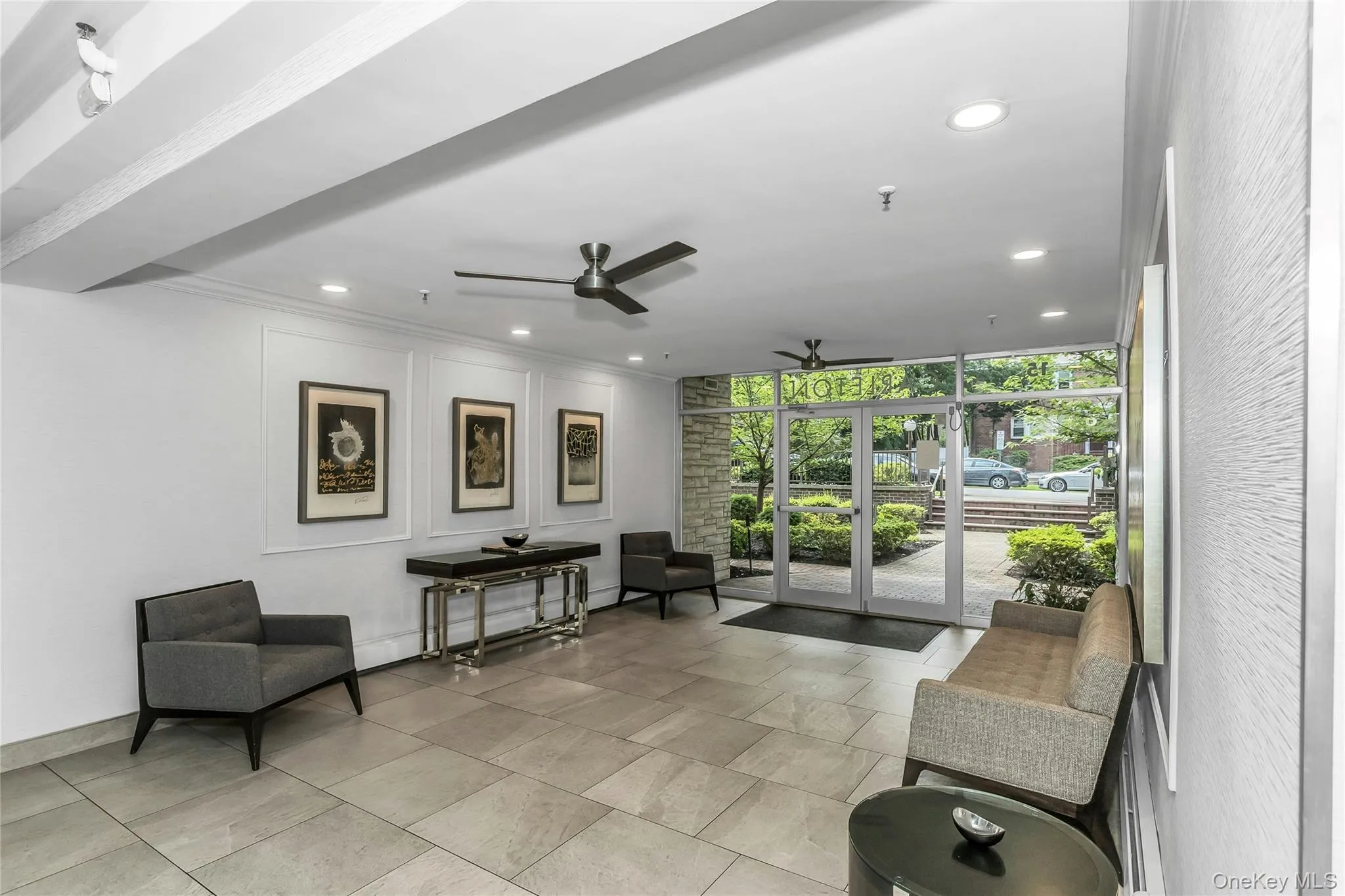 Building lobby with expansive windows, recessed lighting, crown molding, and a decorative wall Building lobby with expansive windows, recessed lighting, crown molding, and a decorative wall