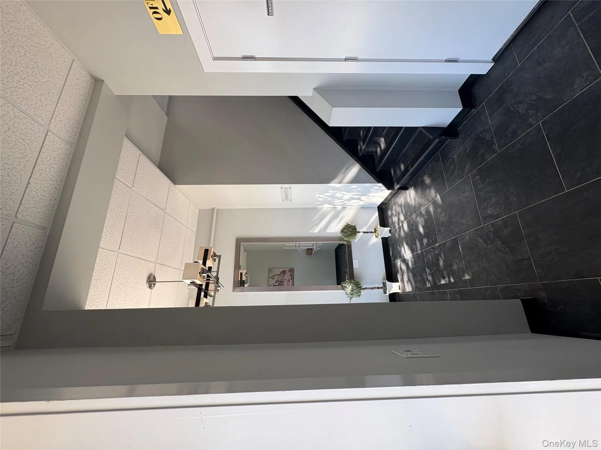 Hall featuring a paneled ceiling, stairway, and a chandelier Hall featuring a paneled ceiling, stairway, and a chandelier