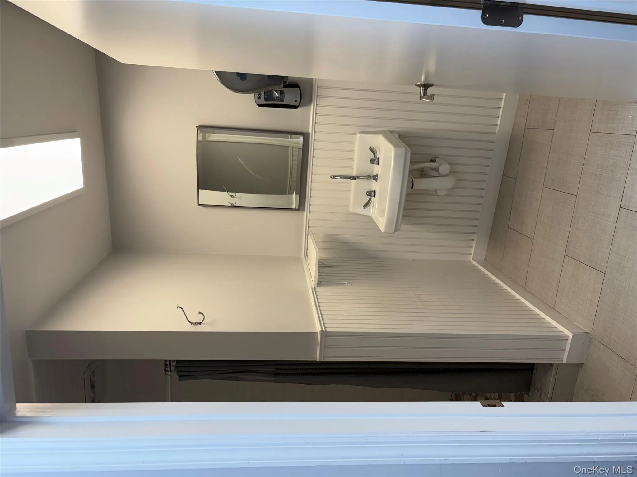 Full bath with a shower with shower curtain, a wainscoted wall, and light tile patterned floors Full bath with a shower with shower curtain, a wainscoted wall, and light tile patterned floors