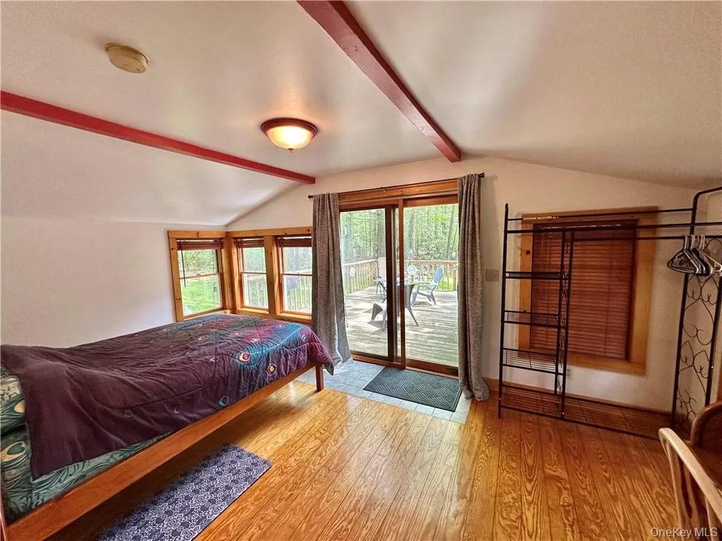 Bedroom featuring light wood-style flooring and access to outside Bedroom featuring light wood-style flooring and access to outside