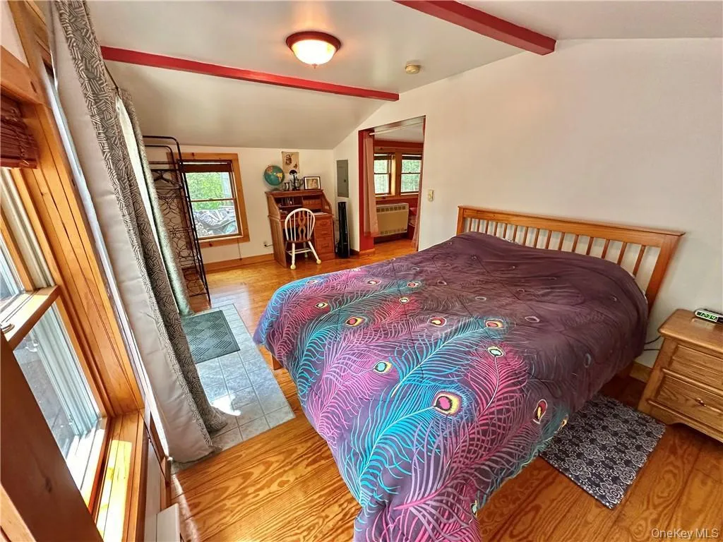 Bedroom featuring wood finished floors and radiator heating unit Bedroom featuring wood finished floors and radiator heating unit