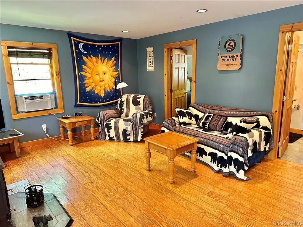 Living area featuring light wood-style flooring, recessed lighting, and cooling unit Living area featuring light wood-style flooring, recessed lighting, and cooling unit