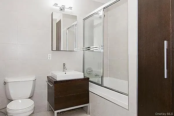 Full bathroom featuring combined bath / shower with glass door and vanity Full bathroom featuring combined bath / shower with glass door and vanity