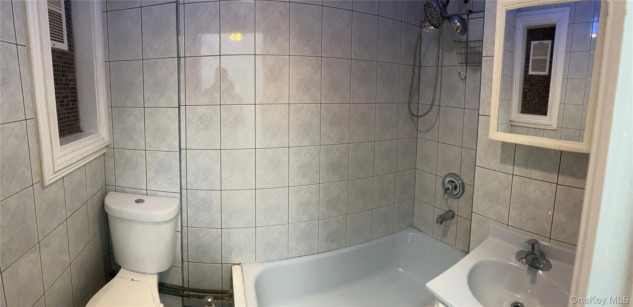 Bathroom with tub / shower combination, tile walls, and vanity Bathroom with tub / shower combination, tile walls, and vanity