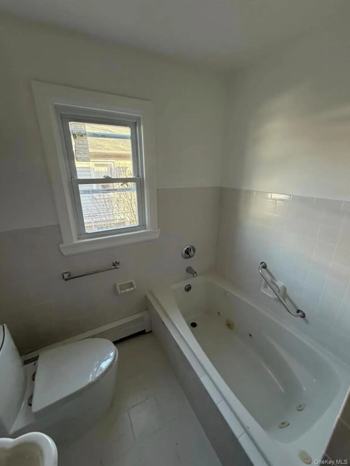 Full bathroom featuring toilet and a jetted tub Full bathroom featuring toilet and a jetted tub