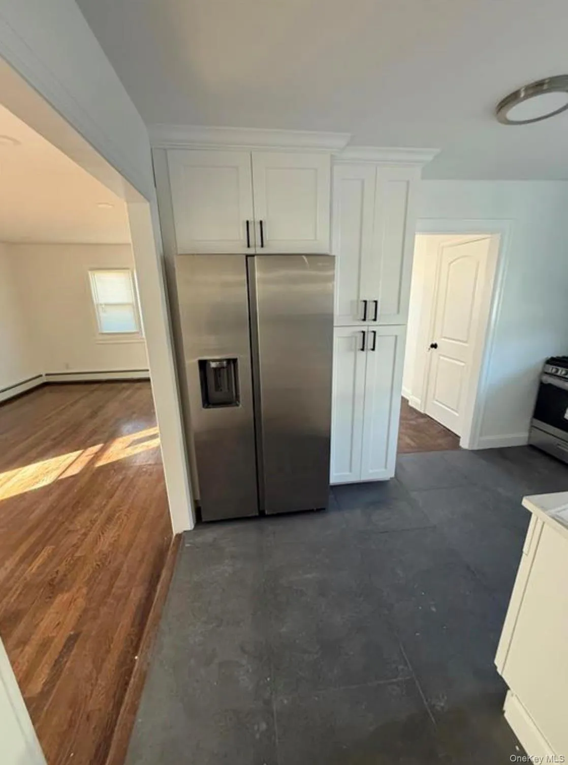 Kitchen featuring appliances with stainless steel finishes, white cabinetry, and baseboards Kitchen featuring appliances with stainless steel finishes, white cabinetry, and baseboards