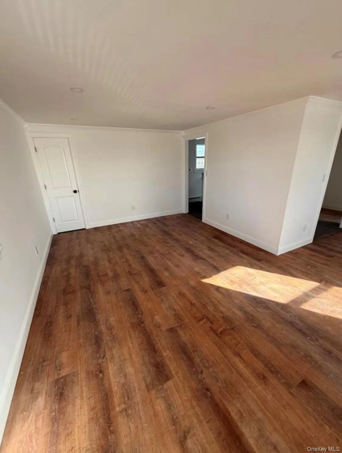 Empty room with dark wood finished floors and baseboards Empty room with dark wood finished floors and baseboards