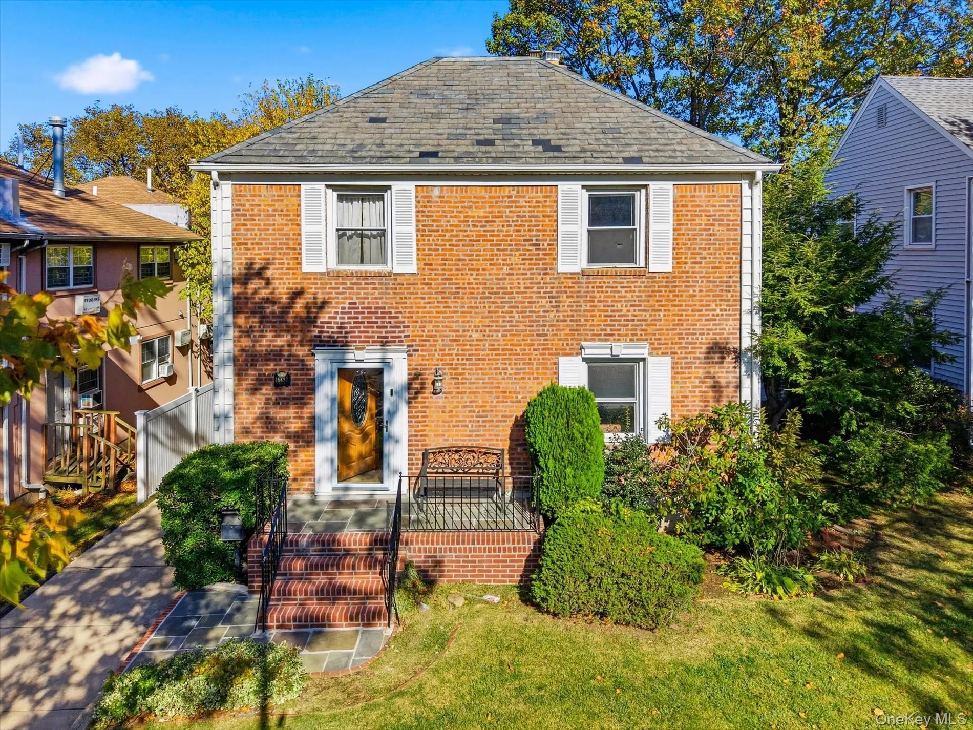 Colonial house featuring brick siding and a front yard Colonial house featuring brick siding and a front yard