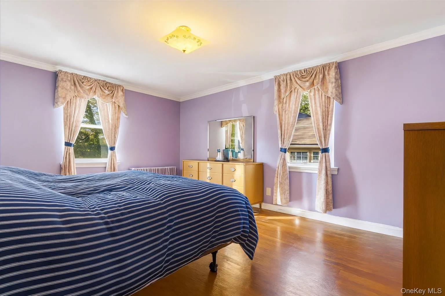 Bedroom featuring crown molding and wood finished floors Bedroom featuring crown molding and wood finished floors