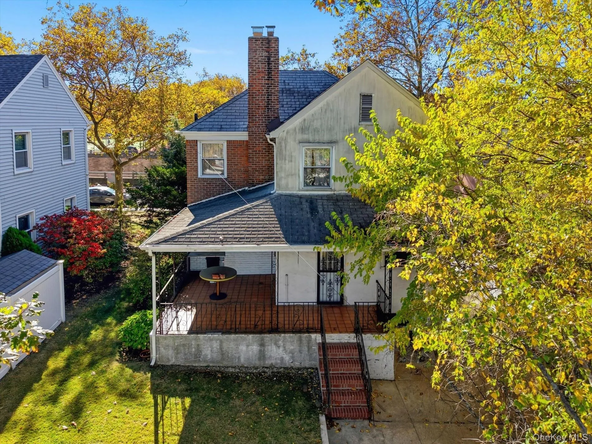Rear view of property featuring a chimney, a lawn, and brick siding Rear view of property featuring a chimney, a lawn, and brick siding
