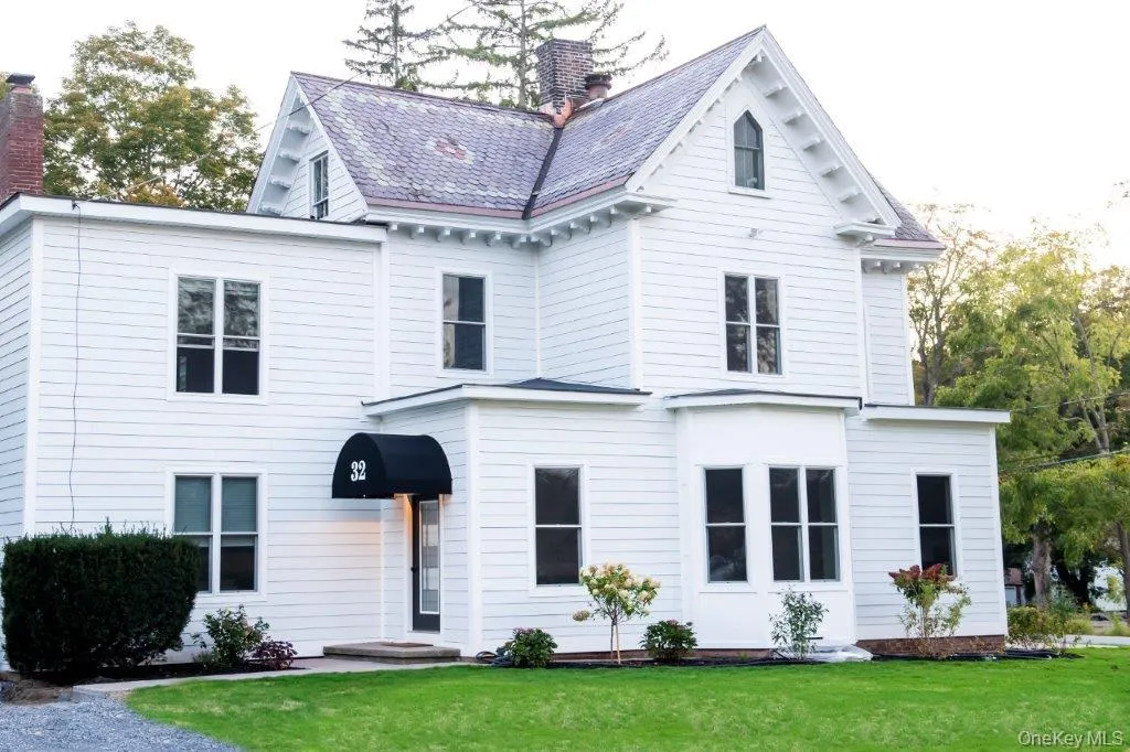 Victorian house featuring a chimney and a front yard Victorian house featuring a chimney and a front yard