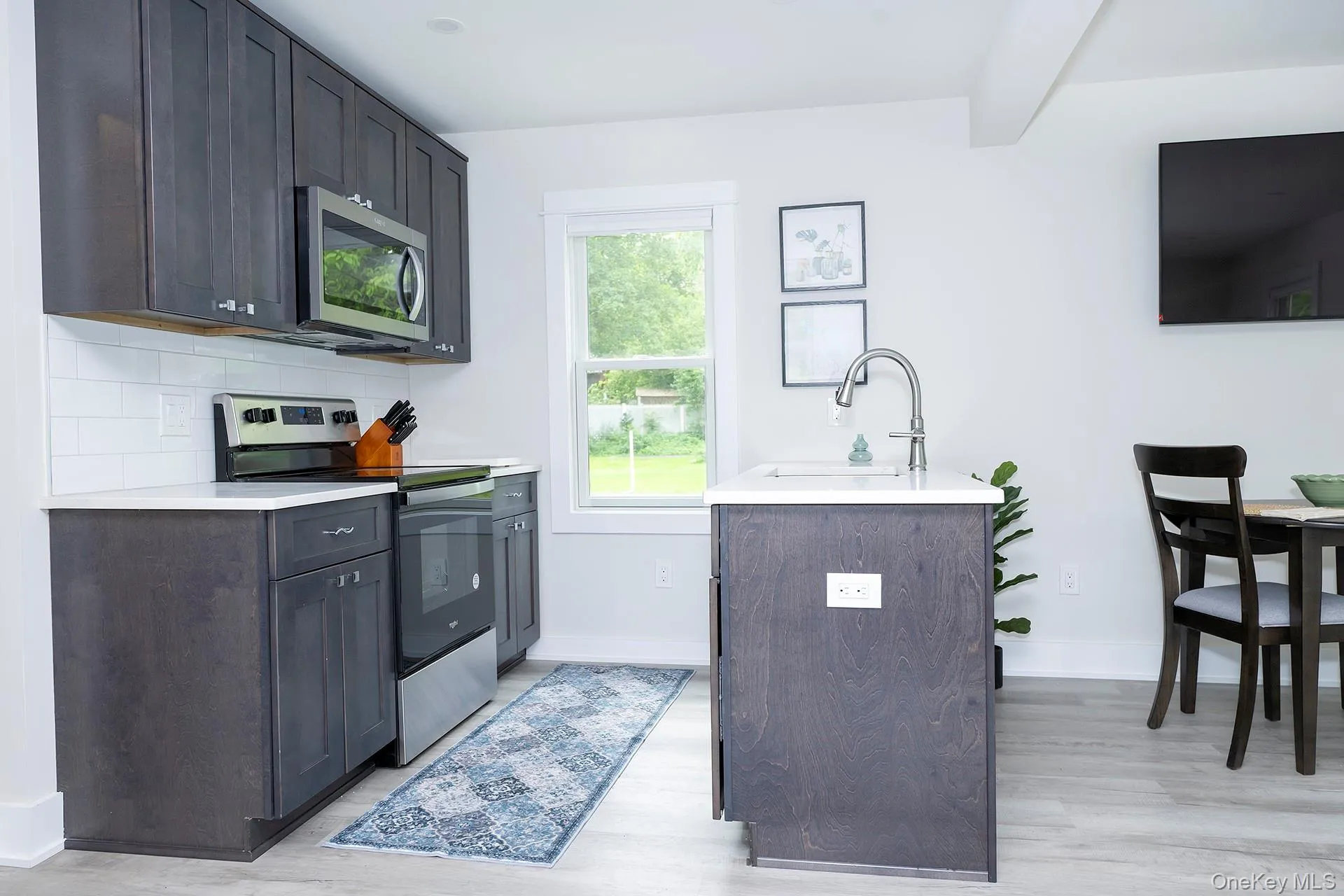 Kitchen featuring stainless steel appliances, backsplash, and light wood finished floors Kitchen featuring stainless steel appliances, backsplash, and light wood finished floors