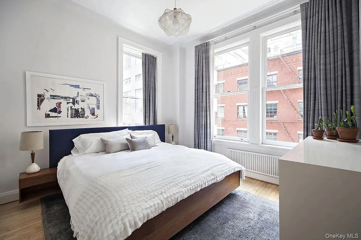 Bedroom featuring light wood finished floors and radiator heating unit Bedroom featuring light wood finished floors and radiator heating unit
