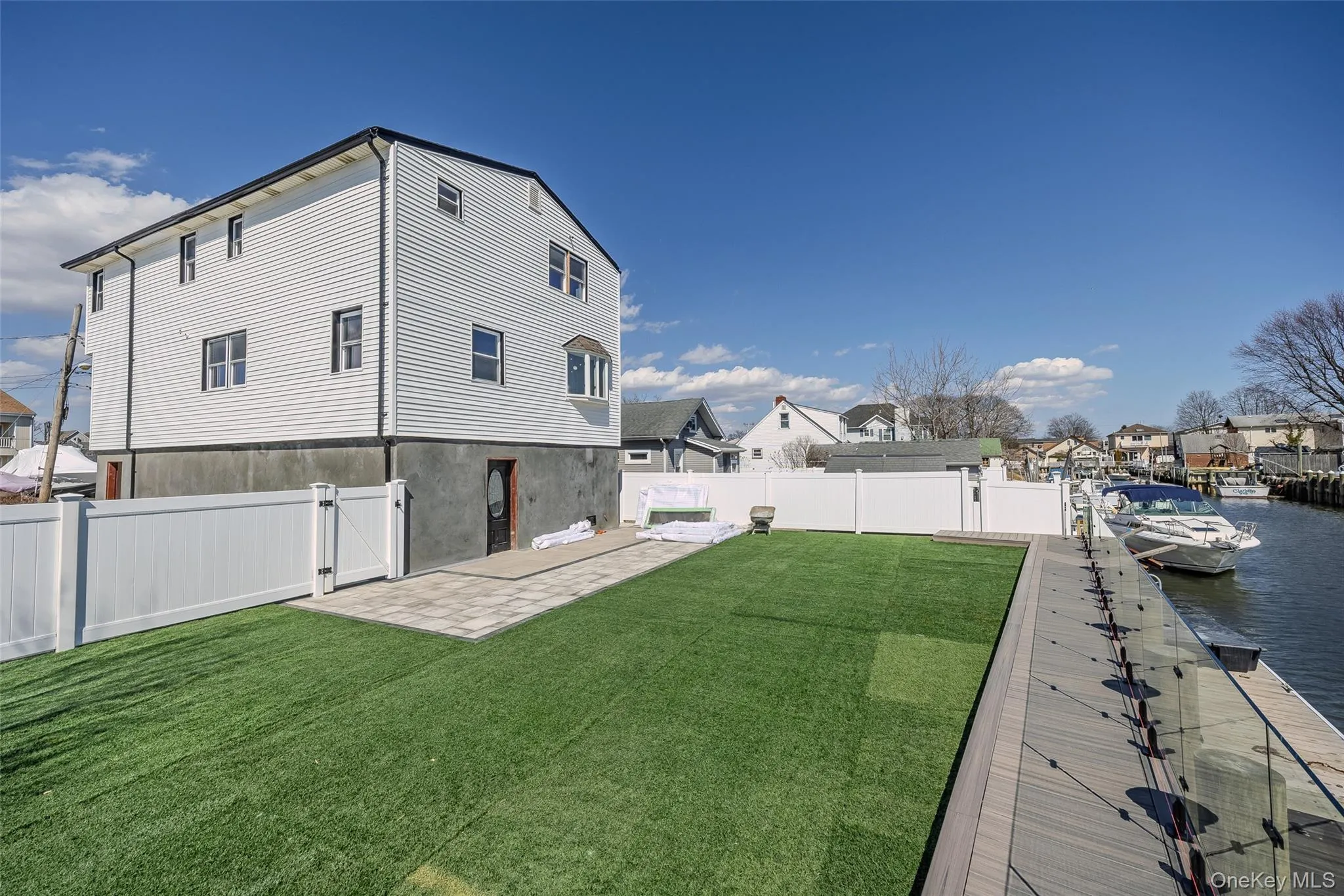 Fenced backyard with a patio area, a gate, and a residential view Fenced backyard with a patio area, a gate, and a residential view
