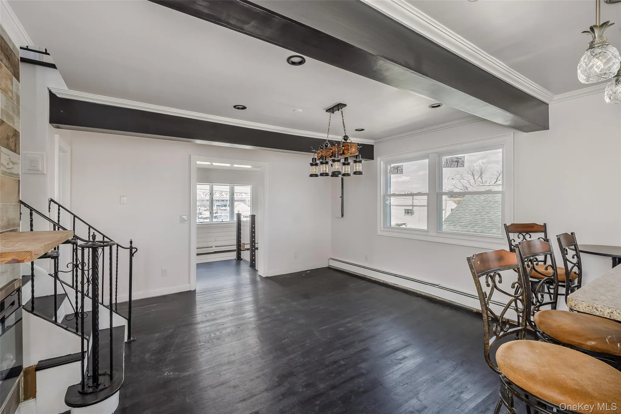 Sitting room with dark wood-style flooring, crown molding, baseboard heating, and beamed ceiling Sitting room with dark wood-style flooring, crown molding, baseboard heating, and beamed ceiling