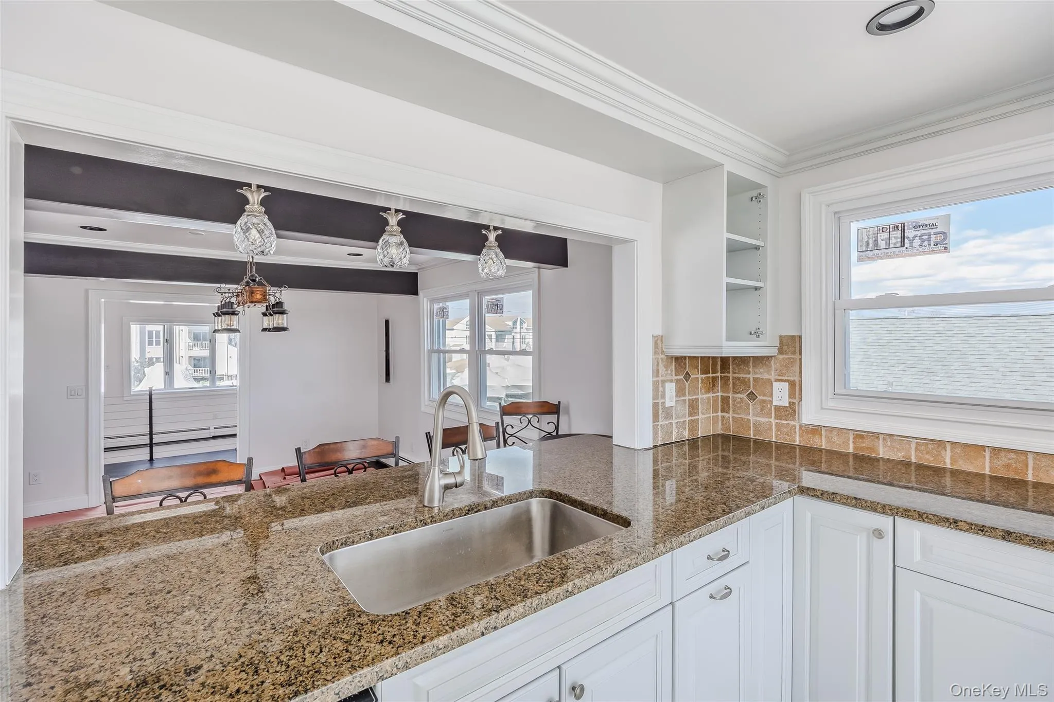 Kitchen featuring white cabinets, crown molding, plenty of natural light, and open shelves Kitchen featuring white cabinets, crown molding, plenty of natural light, and open shelves
