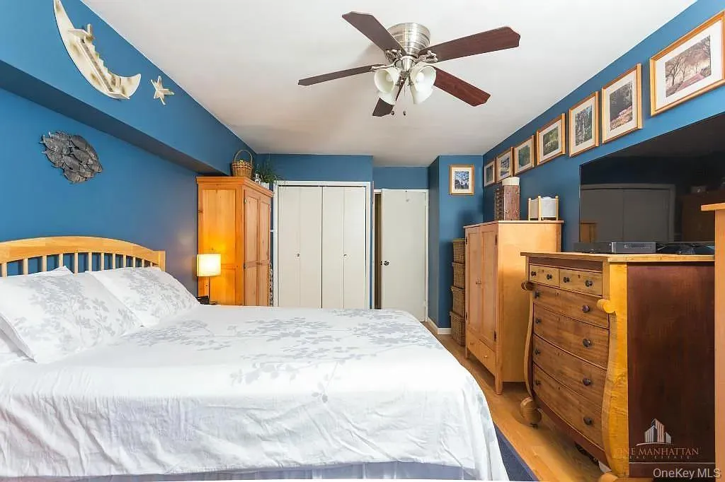 Bedroom with a closet, wood finished floors, and ceiling fan Bedroom with a closet, wood finished floors, and ceiling fan