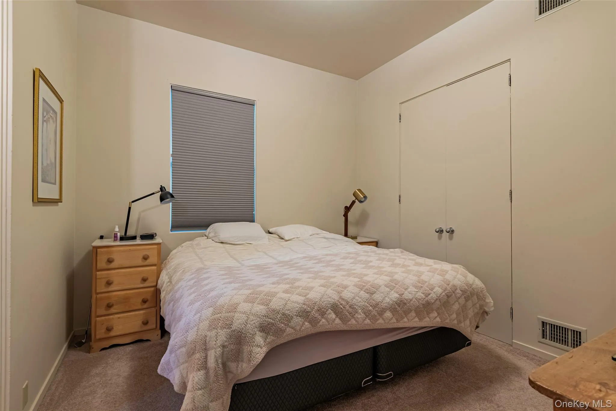 Carpeted bedroom with a closet and baseboards Carpeted bedroom with a closet and baseboards