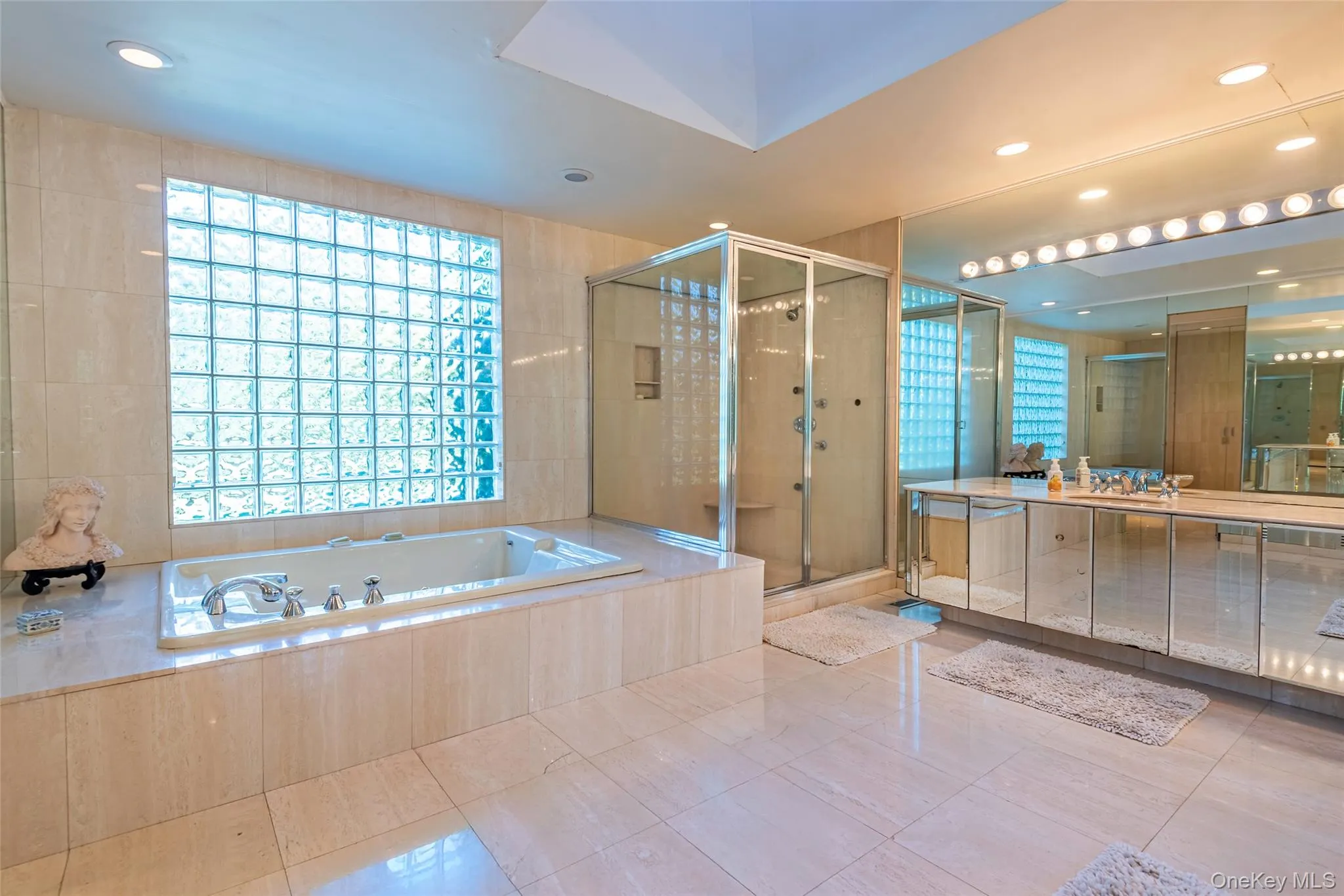 Bathroom featuring a bath, vanity, a stall shower, recessed lighting, and tile walls Bathroom featuring a bath, vanity, a stall shower, recessed lighting, and tile walls
