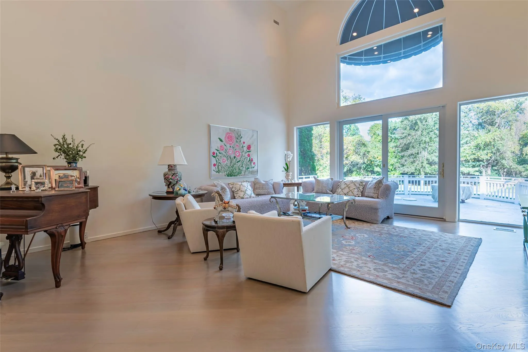 Living room with light wood-style floors and a high ceiling Living room with light wood-style floors and a high ceiling