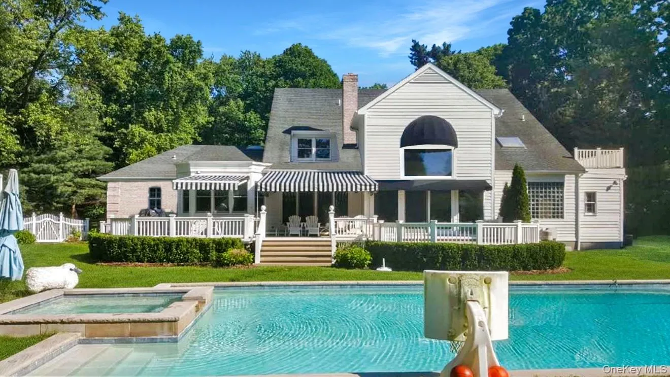 Rear view of property with a patio area, a yard, a chimney, roof with shingles, and a pool with connected hot tub Rear view of property with a patio area, a yard, a chimney, roof with shingles, and a pool with connected hot tub