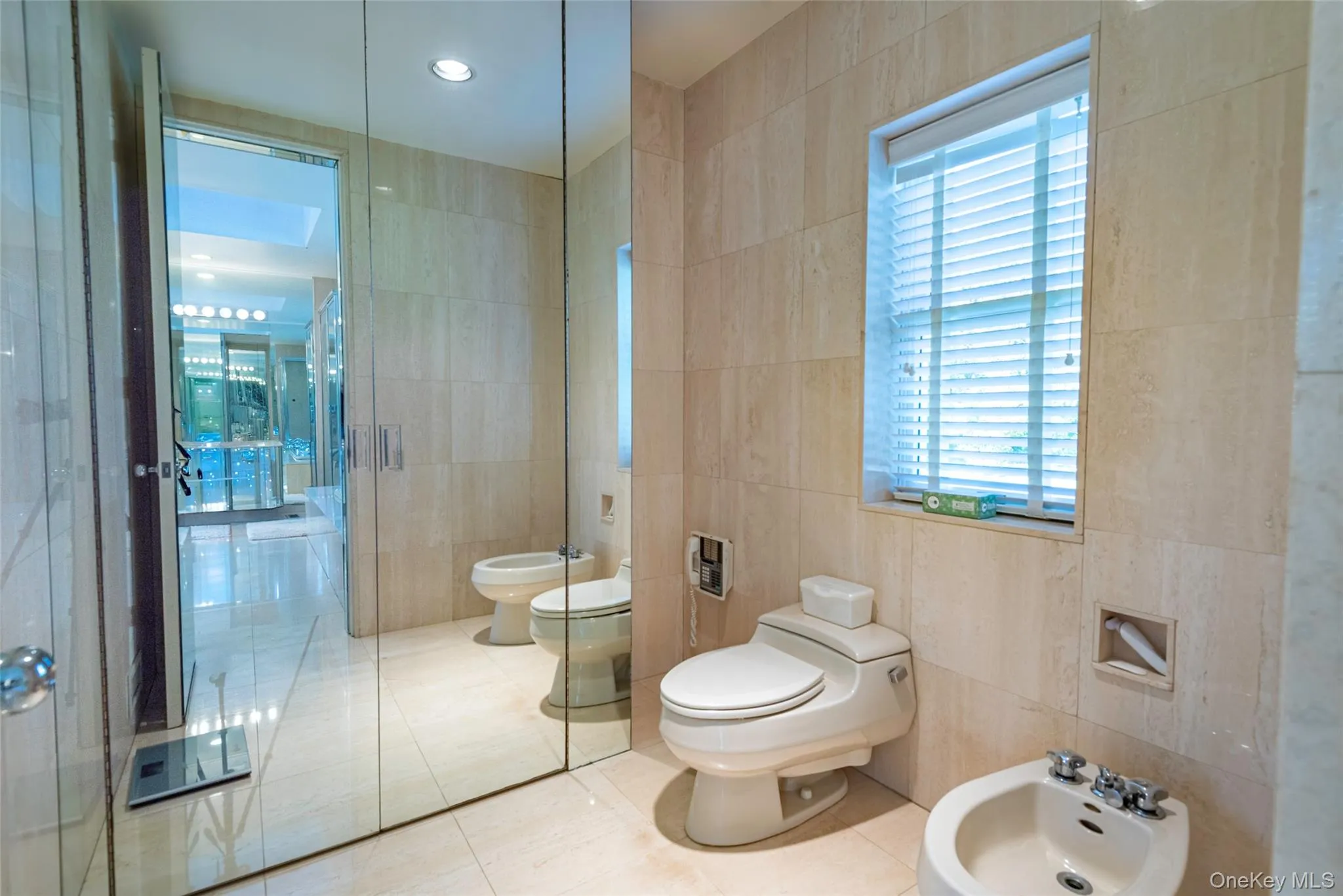 Bathroom with a bidet, tile walls, tile patterned floors, plenty of natural light, and recessed lighting Bathroom with a bidet, tile walls, tile patterned floors, plenty of natural light, and recessed lighting