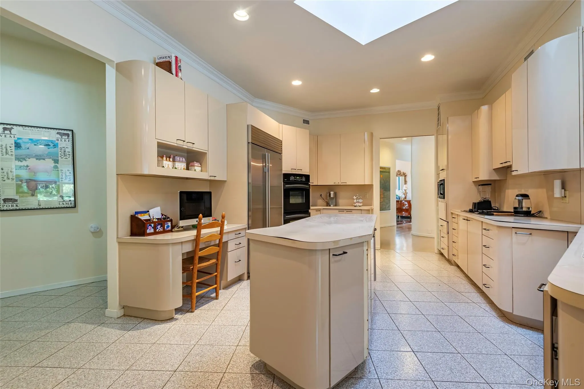 Kitchen with crown molding, light countertops, a skylight, recessed lighting, and a kitchen island Kitchen with crown molding, light countertops, a skylight, recessed lighting, and a kitchen island