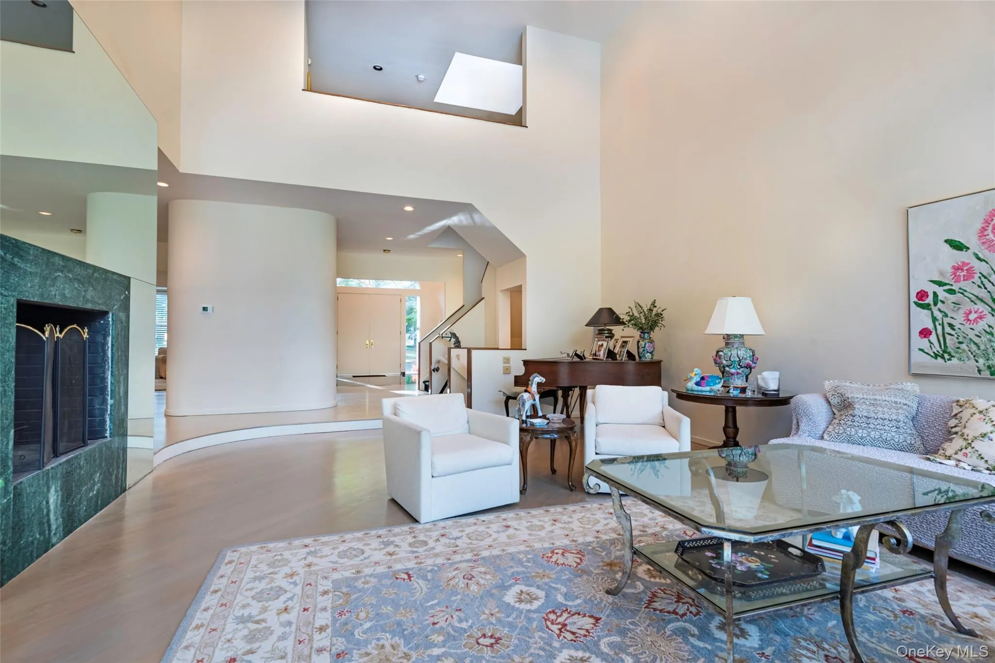 Living area with a high ceiling, a tiled fireplace, and stairs Living area with a high ceiling, a tiled fireplace, and stairs