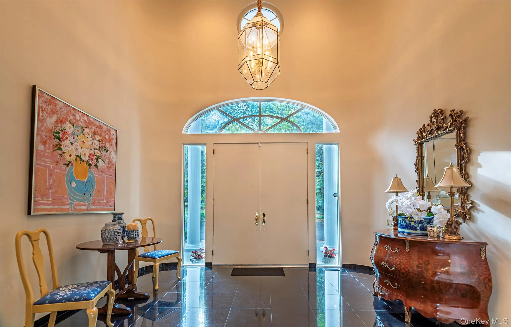 Entryway featuring a chandelier, a high ceiling, and granite tiled floors Entryway featuring a chandelier, a high ceiling, and granite tiled floors