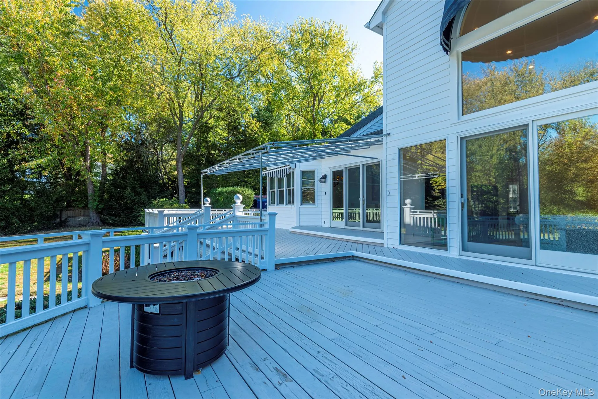 Wooden terrace with a fire pit and view of wooded area Wooden terrace with a fire pit and view of wooded area