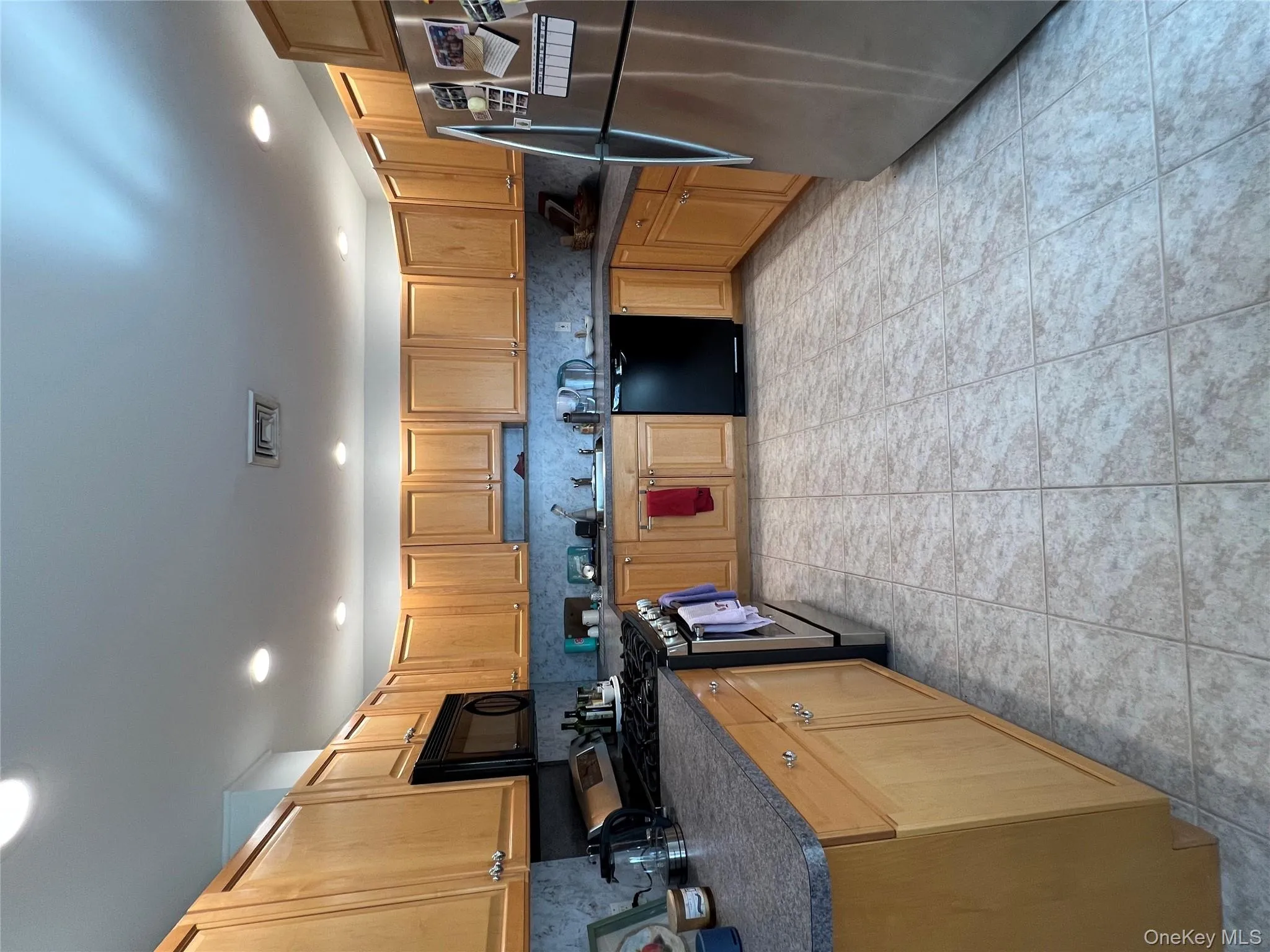 Kitchen featuring refrigerator, dark countertops, range, dishwashing machine, and recessed lighting Kitchen featuring refrigerator, dark countertops, range, dishwashing machine, and recessed lighting