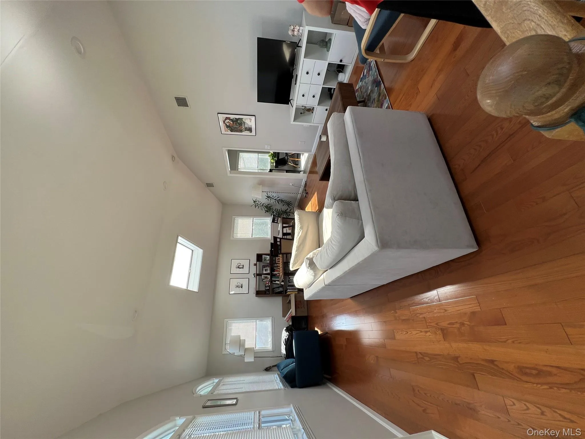 Living room with a skylight, lofted ceiling, hardwood / wood-style flooring, and healthy amount of natural light Living room with a skylight, lofted ceiling, hardwood / wood-style flooring, and healthy amount of natural light