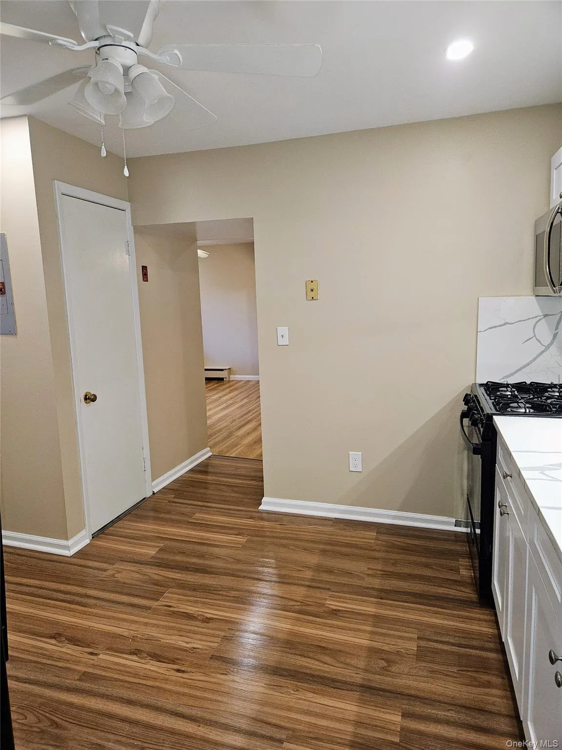 Looking from hallway across kitchen toward living room. Looking from hallway across kitchen toward living room.