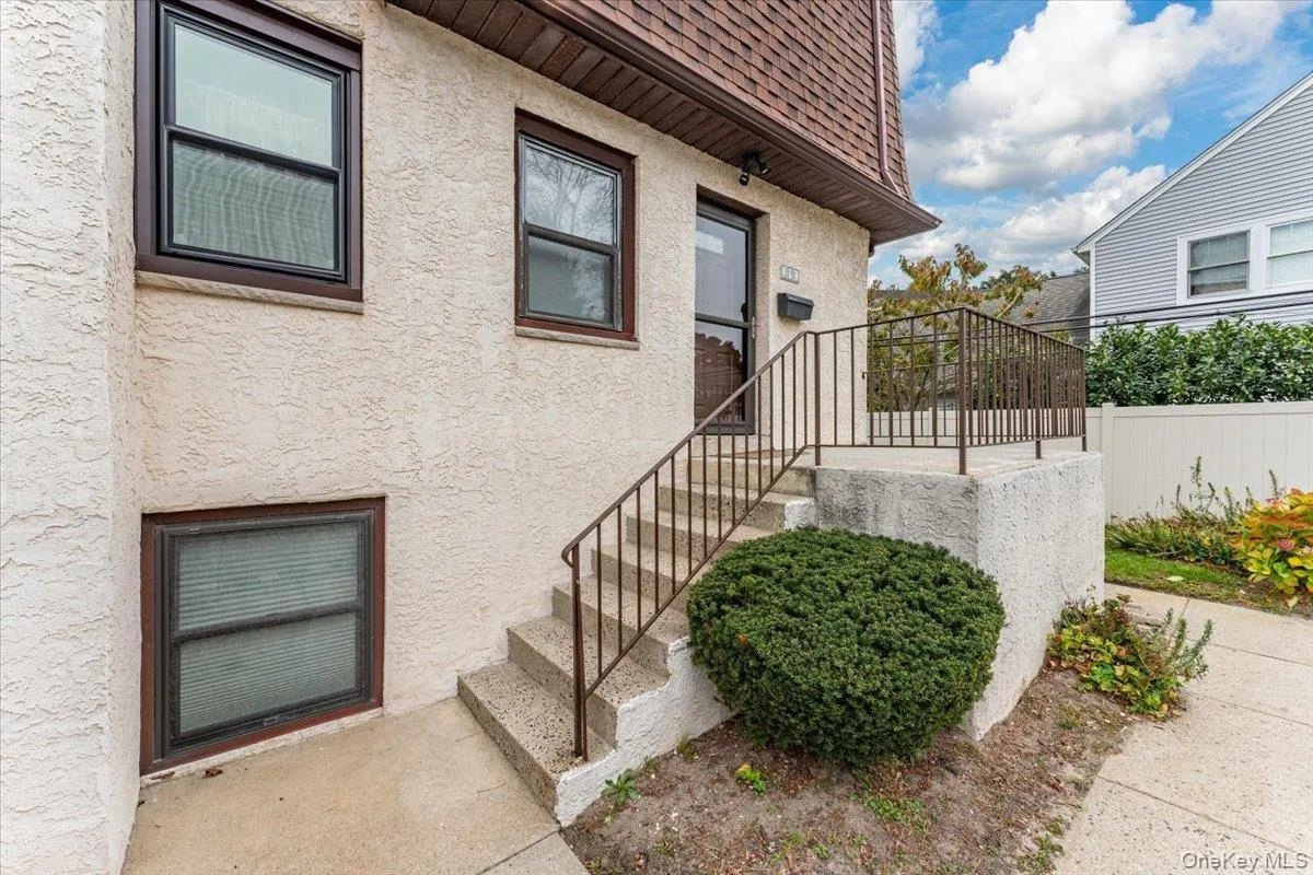 Doorway to property featuring stucco siding and a shingled roof Doorway to property featuring stucco siding and a shingled roof