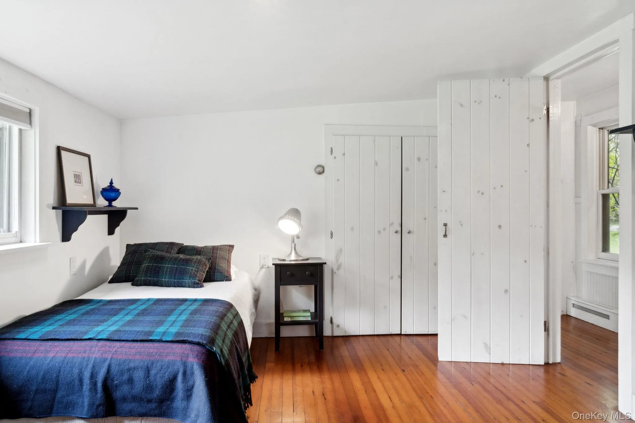 Bedroom featuring hardwood / wood-style flooring and a baseboard radiator Bedroom featuring hardwood / wood-style flooring and a baseboard radiator