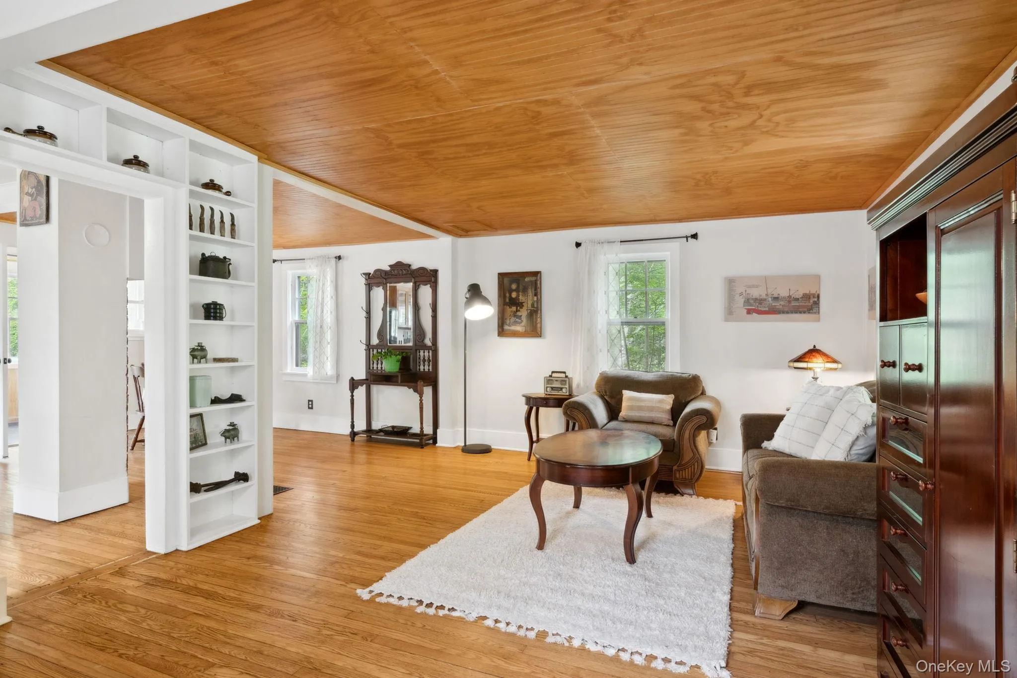 Living area featuring wood ceiling, built in features, and light wood-style flooring Living area featuring wood ceiling, built in features, and light wood-style flooring