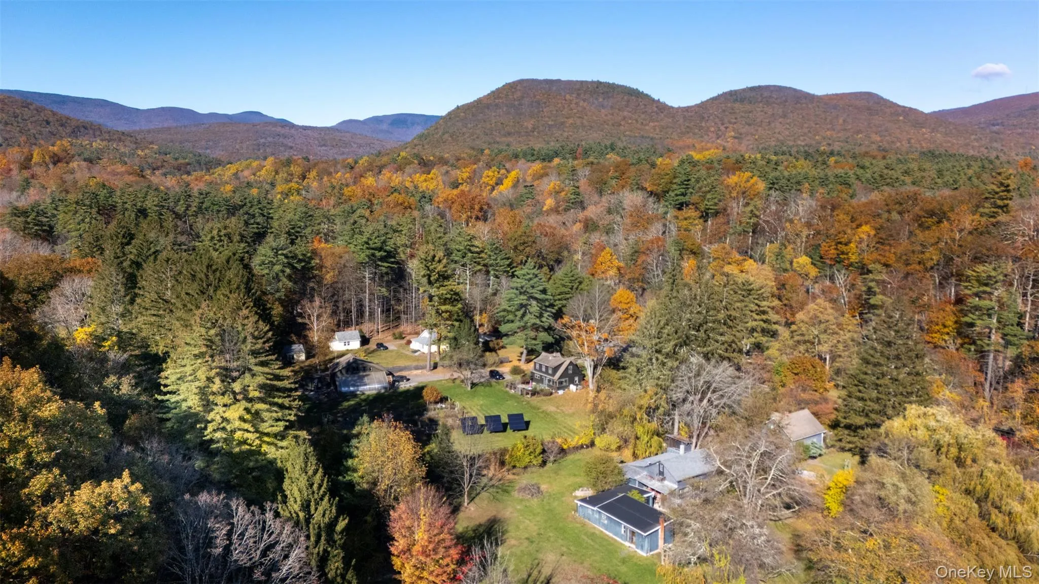 Aerial overview of property's location featuring a forest and a mountain backdrop Aerial overview of property's location featuring a forest and a mountain backdrop