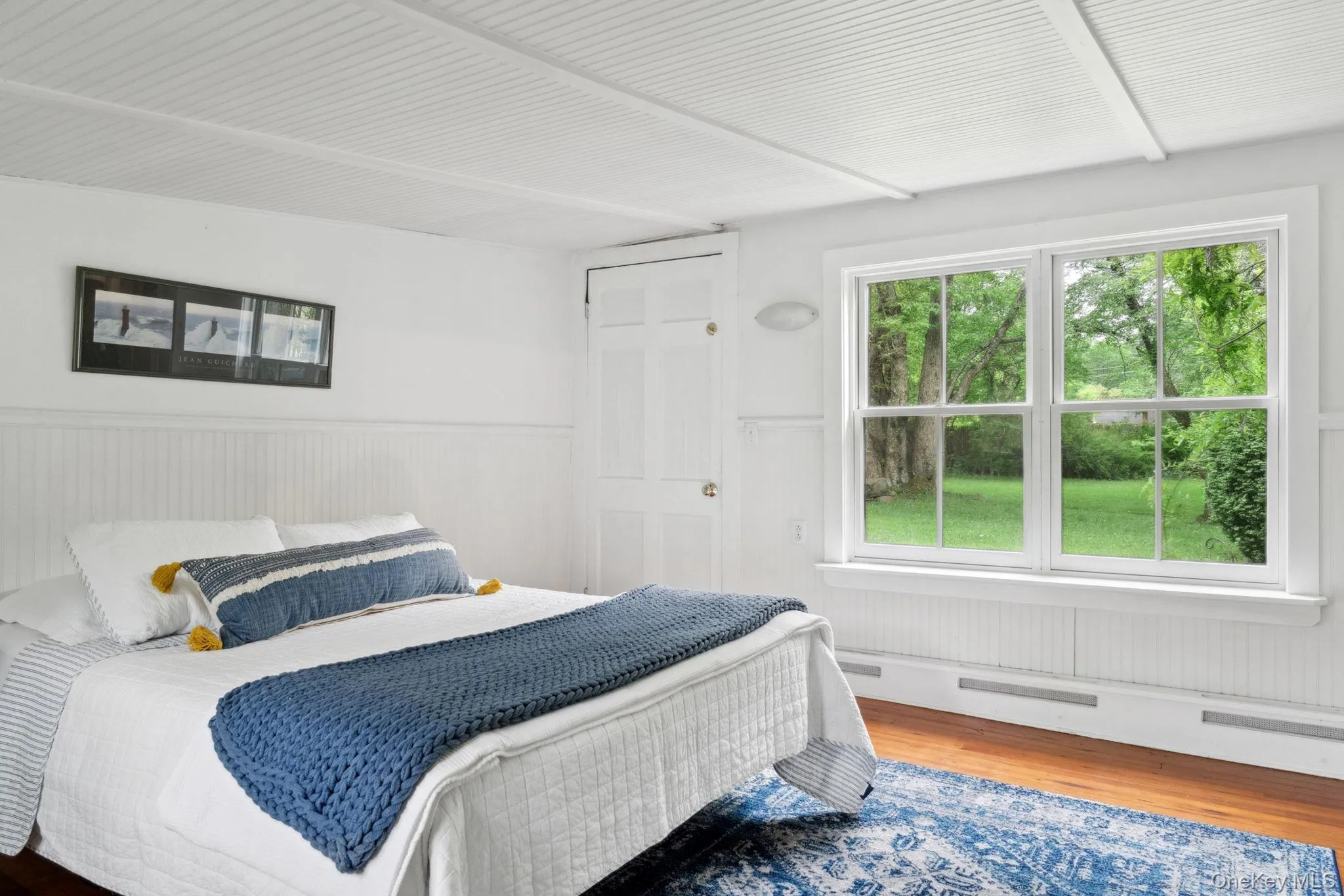 Bedroom featuring wood finished floors and wainscoting Bedroom featuring wood finished floors and wainscoting