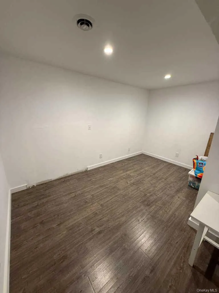 Empty room featuring dark wood-style flooring and recessed lighting Empty room featuring dark wood-style flooring and recessed lighting